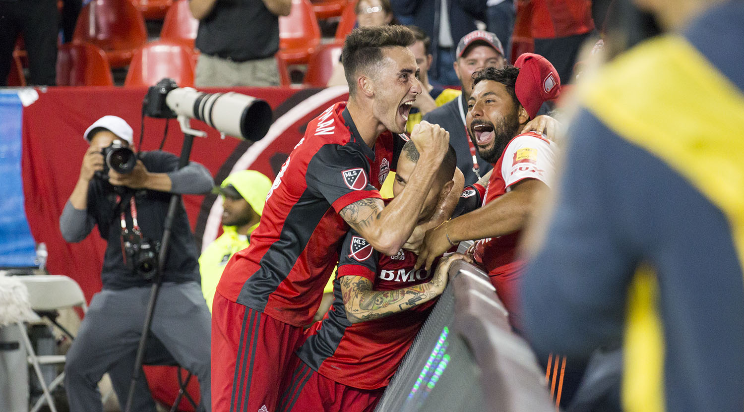 Sebastian Giovinco celebrating with fans as photographers shoot on in celebratoin of a beautiful goal. Image by Dennis Marciniak of denMAR Media.