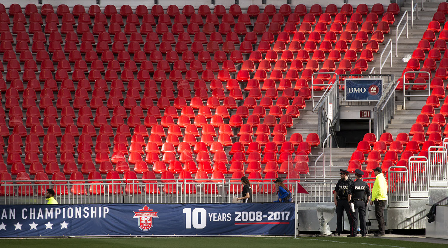 Toronto Police officers watch over the empty stands as staff get the field ready for the Canadian Championship. Image by Dennis Marciniak of denMAR Media.