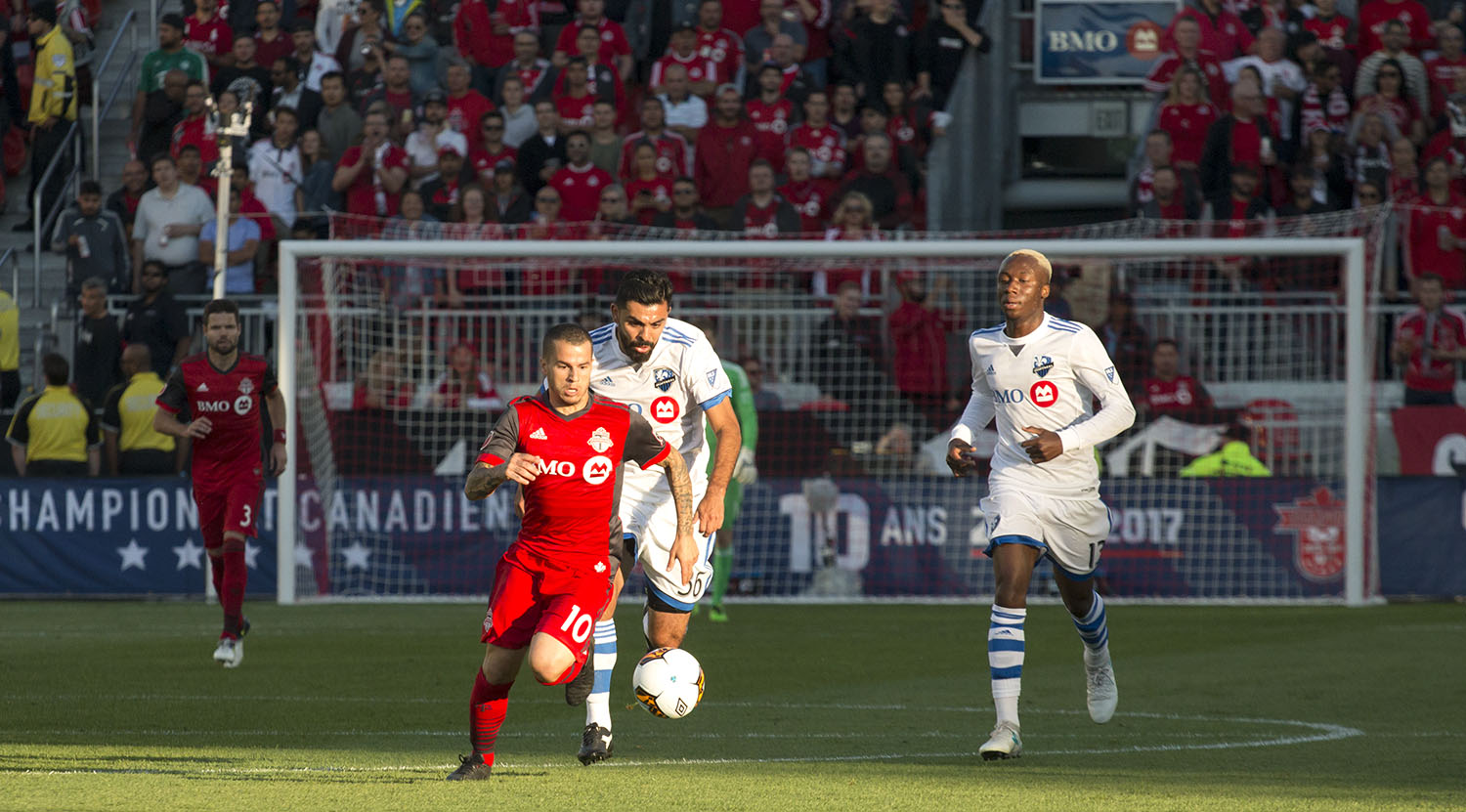 Sebastian Giovinco flies past the Montreal Impact defenders during a game in 2017. Image by Dennis Marciniak of denMAR Media.
