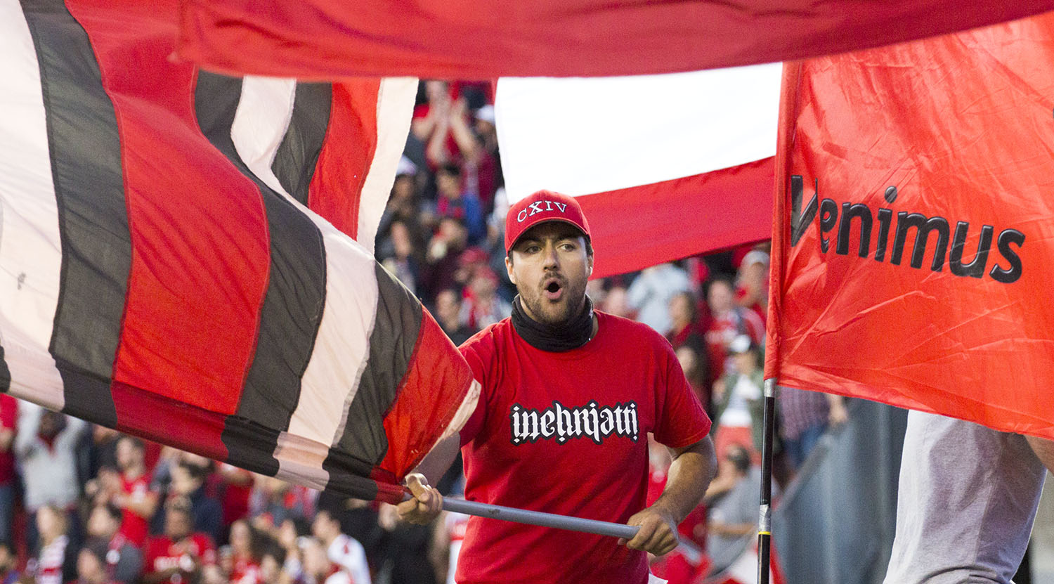 An inebriatti supporter waving a flag among other flags during the Canadian Championship Finale in 2017. Image by Dennis Marciniak of denMAR Media.