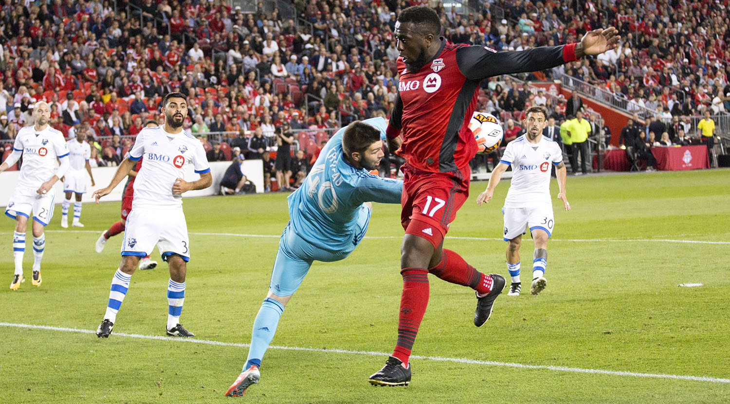 Jozy Altidore tries to get the ball past the Montreal Impact goalkeeper as he snatches it out of the air with his hands. Image by Dennis Marciniak of denMAR Media.