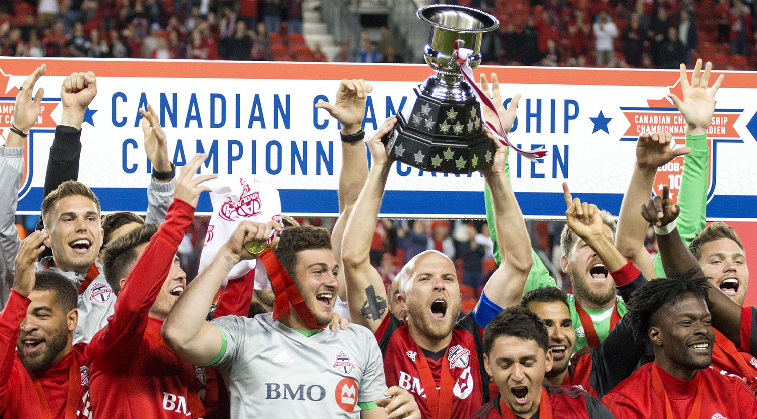 Toronto FC celebrate winning the 2017 Canadian Championship by hoisting the Voyageurs Cup in 2017 at BMO Field. Good job boys! Image by Dennis Marciniak of denMAR Media.