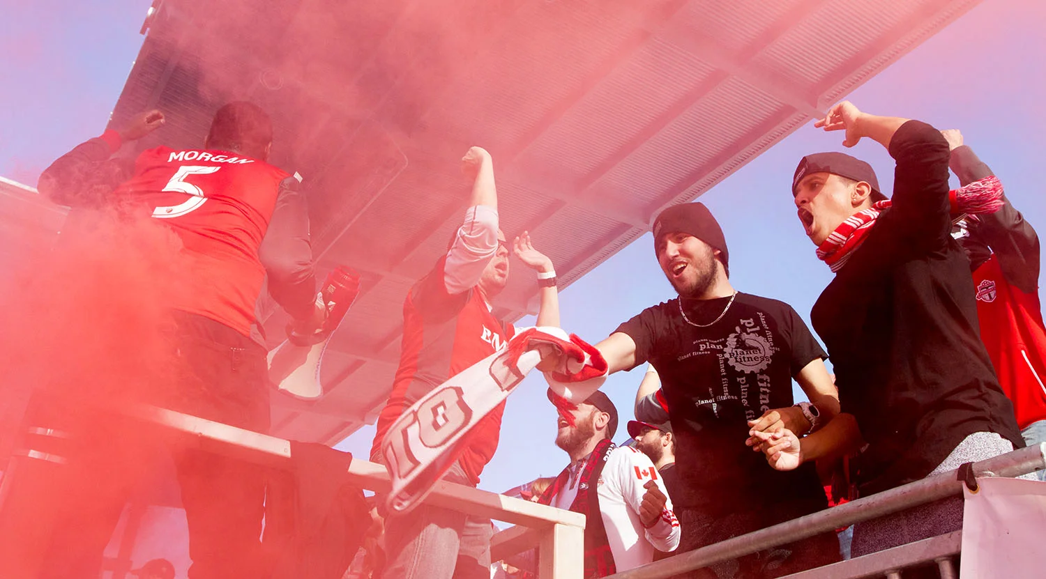 South End supporters celebrate amidst the red smoke after the first goal on the day. Image by Dennis Marciniak.