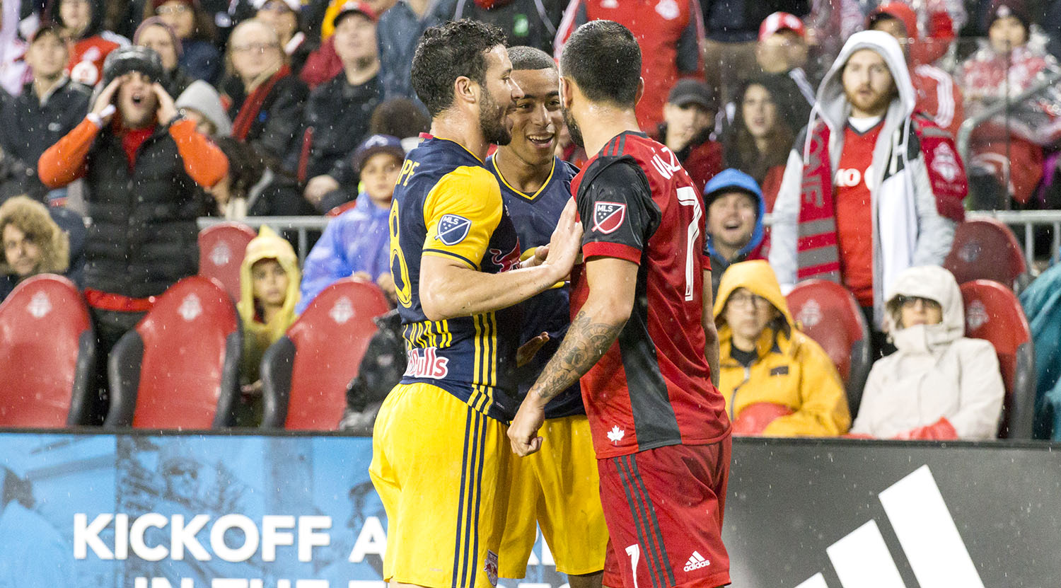 Two NYRB players argue with Víctor Vázquez Solsona during a playoff match in 2017 at BMO Field. Image by Dennis Marciniak of denMAR Media.