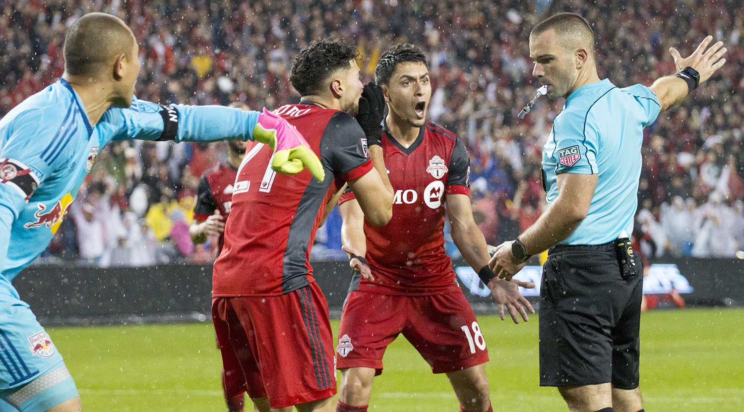 Luis Robles and Marky Delgado argue with the first official Chris Penso as to whether the ball went past the goal line or not. Image by Dennis Marciniak of denMAR Media.