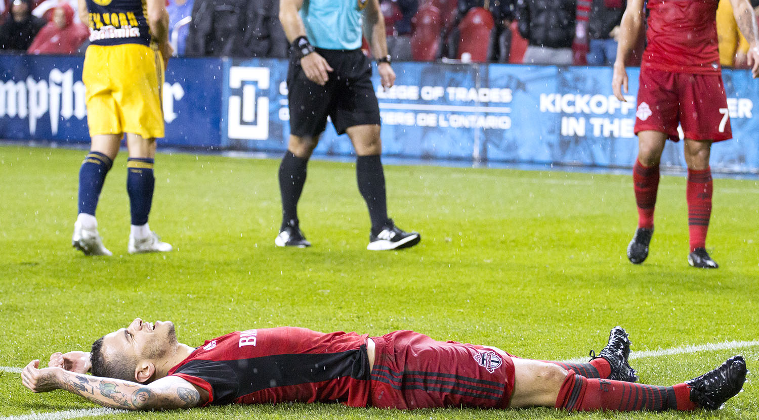 Sebastian Giovinco goes to ground and has a relax as the pouring rain comes down on him during a playoff match in 2017. Image by Dennis Marciniak of denMAR Media.