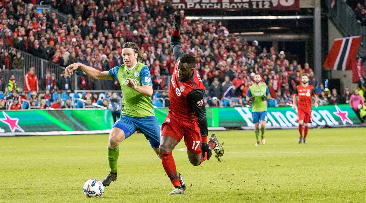 Jozy Altidore looks to take a shot on goal while a Seattle Sounders defender attempts to put a stop to that. Image by Dennis Marciniak of denMAR Media.