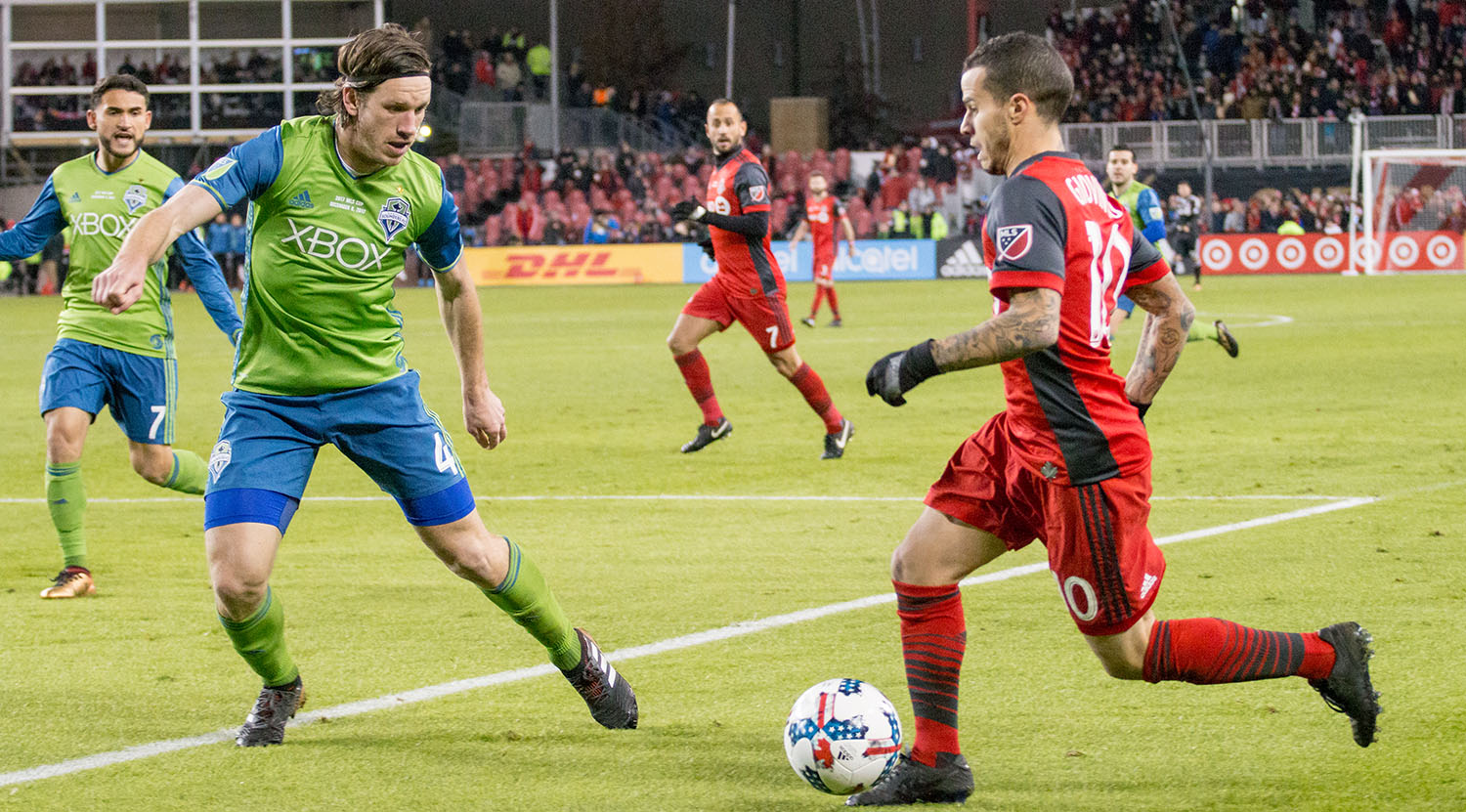 Sebastian Giovinco trying to get around a Seattle Sounder defender at BMO FIeld. Image by Dennis Marciniak of denMAR Media.