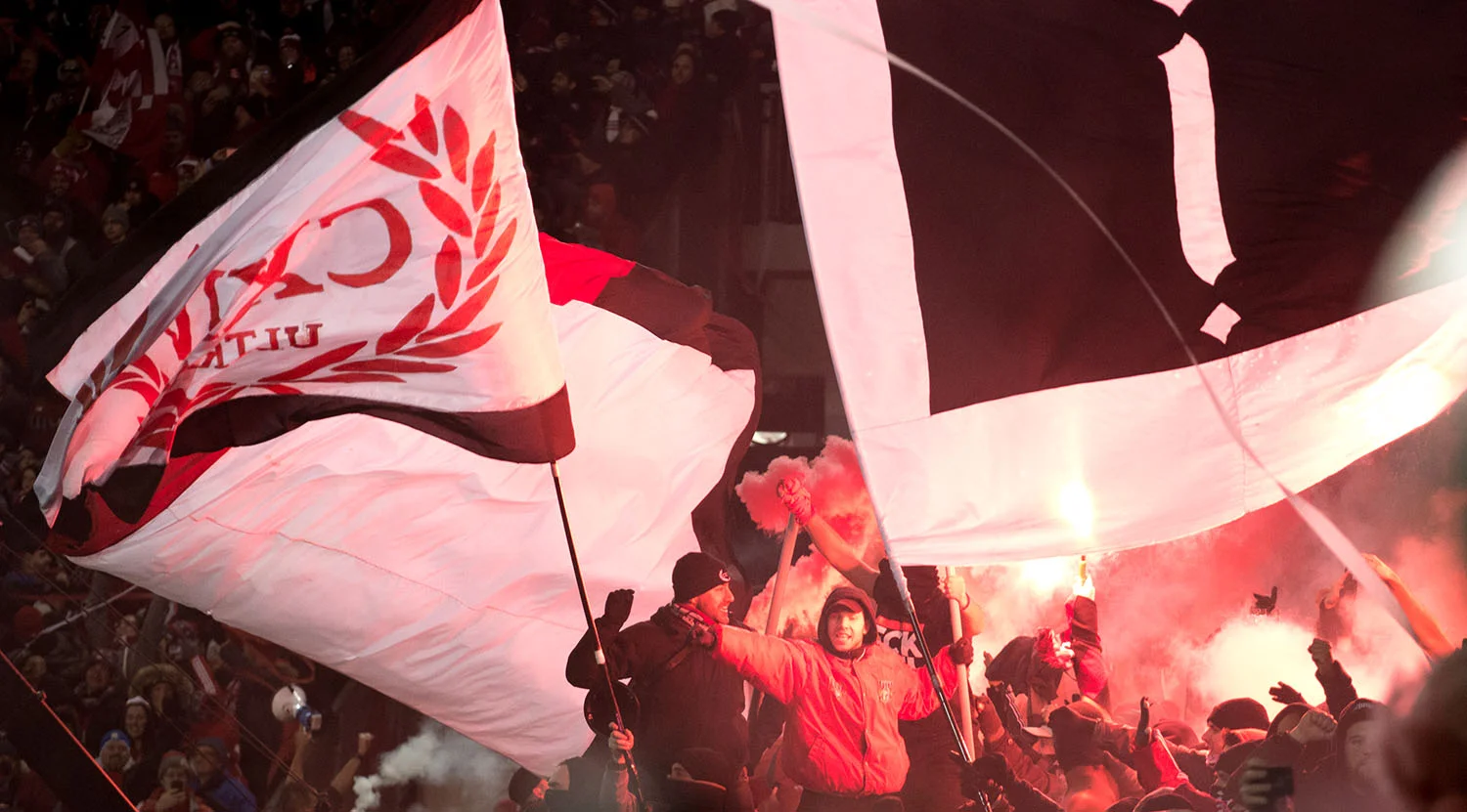 Flares light up the south end supporter's section after the second goal is scored during the MLS Cup at BMO FIeld. Image by Dennis Marciniak of denMAR Media.