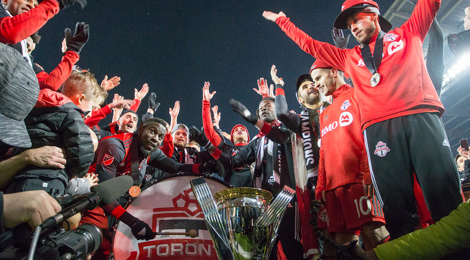 Toronto FC celebrates the treble with the south end supporter's section with a thunder clap. Image by Dennis Marciniak of denMAR Media.
