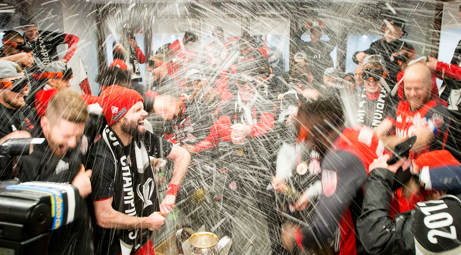Drew Moor celebrates in the locker room as beer and champagne get sprayed everywhere during the MLS Cup 2017 at BMO Field. Image by Dennis Marciniak of denMAR Media.