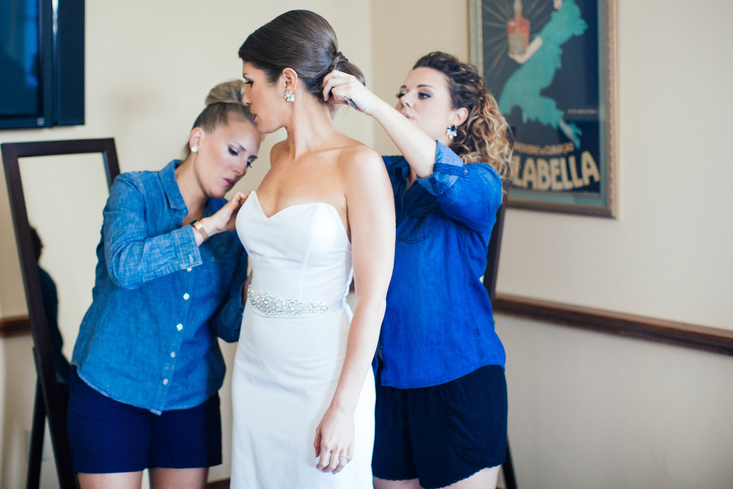 Photo of Bridesmaids helping bride get ready shot by a Minneapolis Wedding Photographer