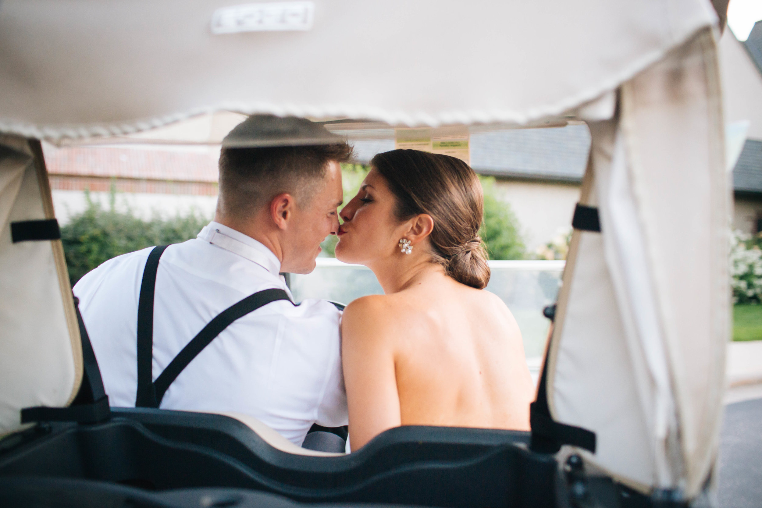 Bride and Groom Kissing in a Golf Cart