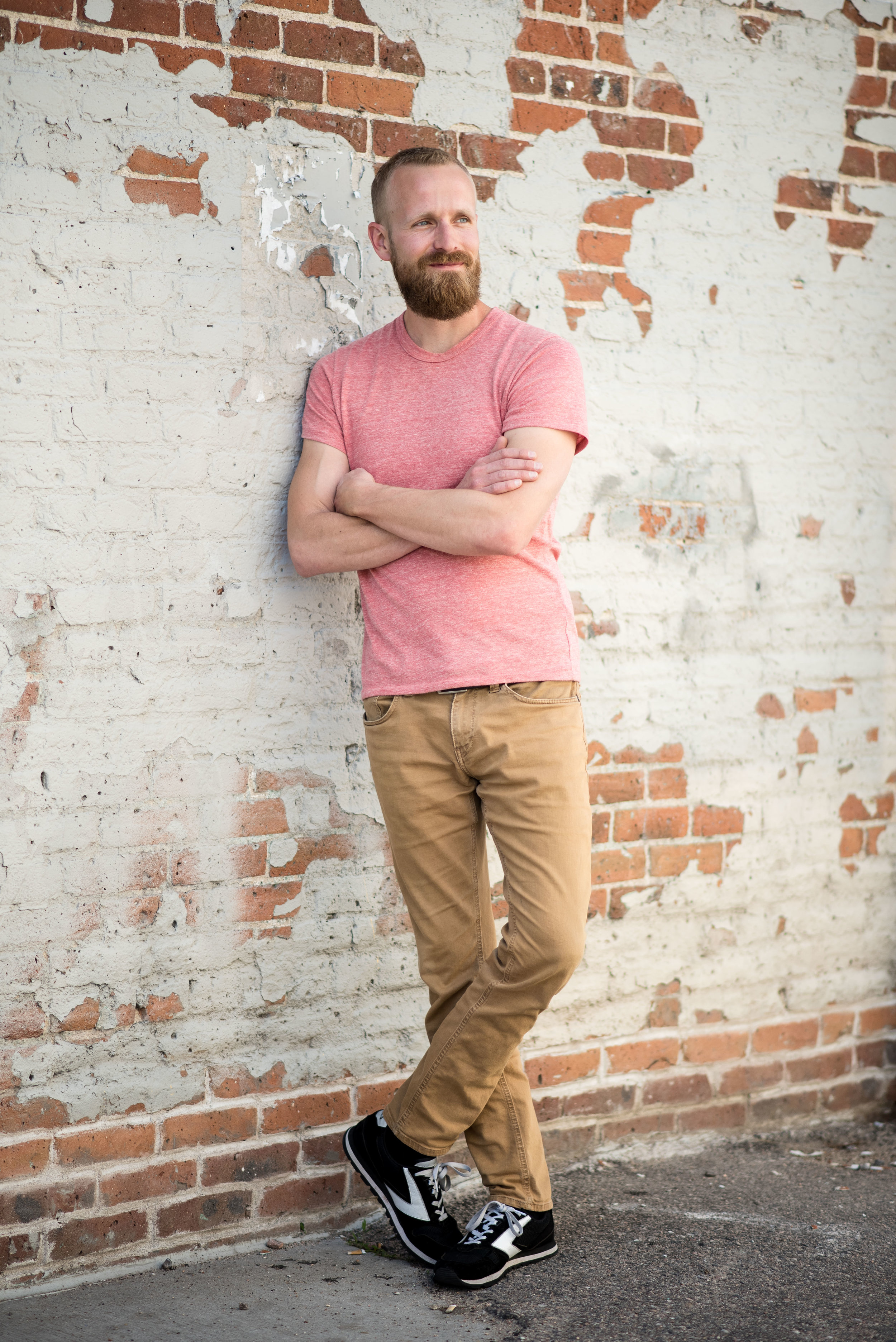 cool guy standing with brick background in denver headshot