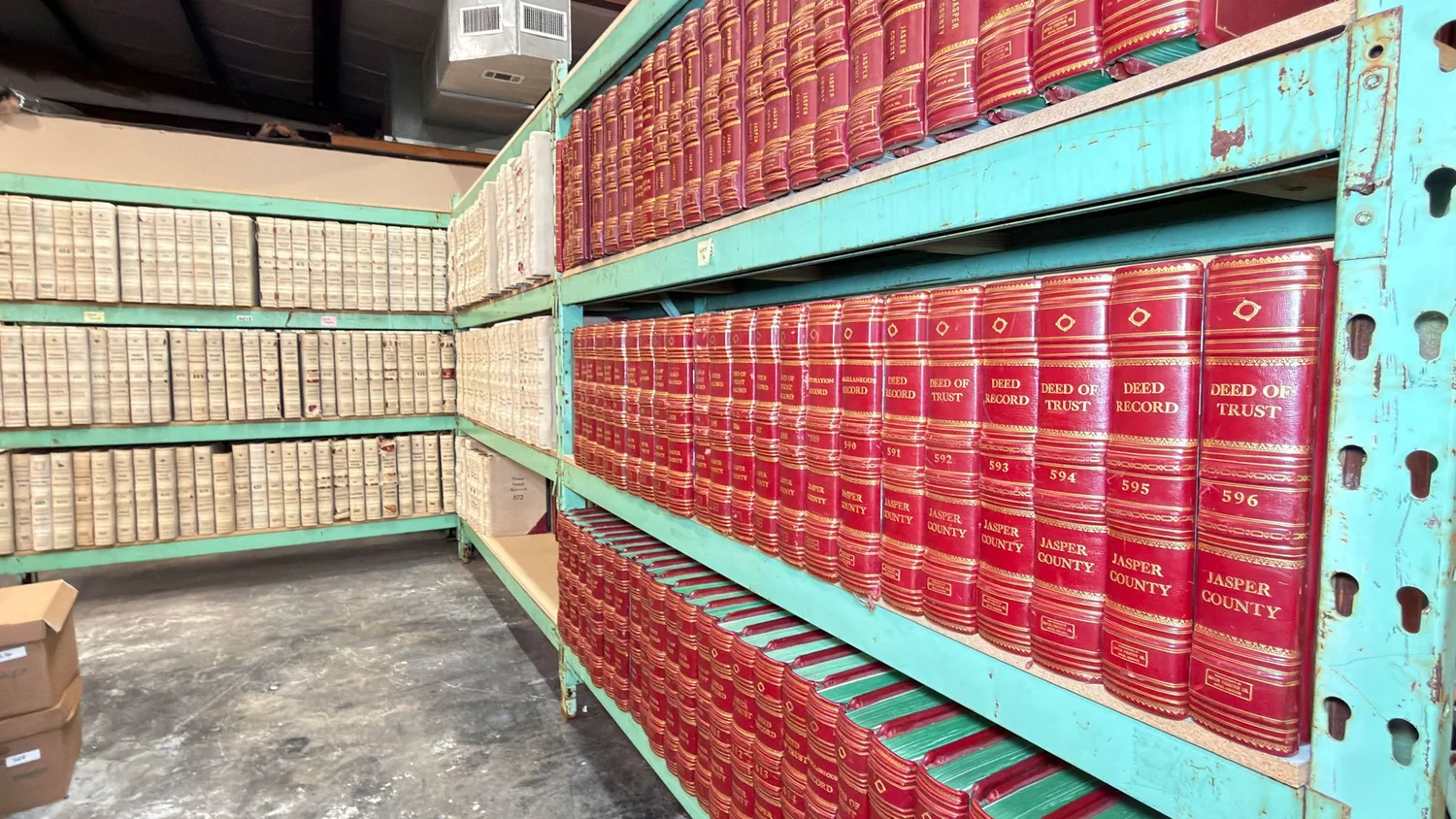 Bound deed record volumes from Jasper County shelved on racking at a Revolution Data Systems facility