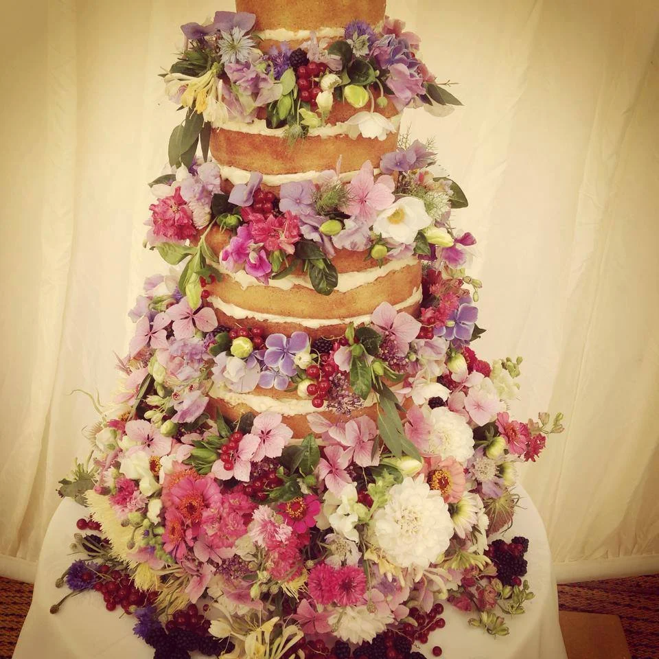 Wedding cake finished with flowers and fruit.