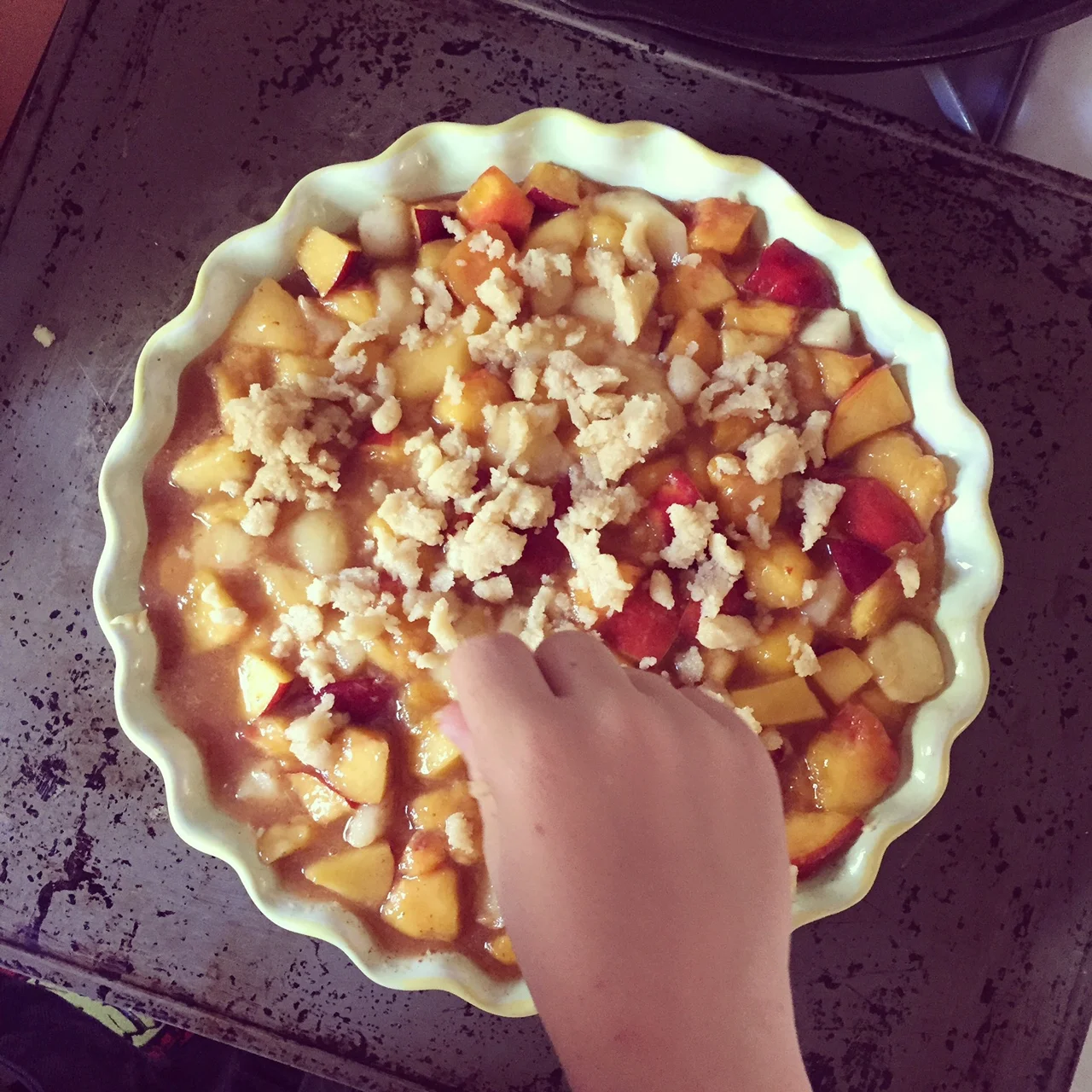 grab a sweet hand or two to help with this part or get in their yourself, i love to crumble the crumble! another tip: it gets real juicy in the fire, so make sure to put your crumble on a baking sheet so you don't set the fire alarm off... i learned from experience! it goes in for about 40 minutes or so depending on your oven.