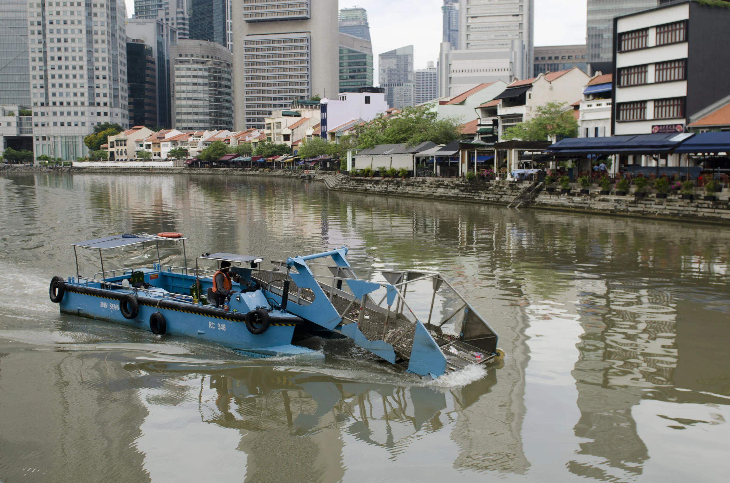 A special boat scooping trash out of the Singapore River