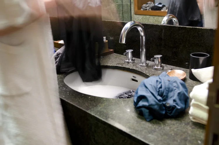 Doing laundry in the bathroom sink in India