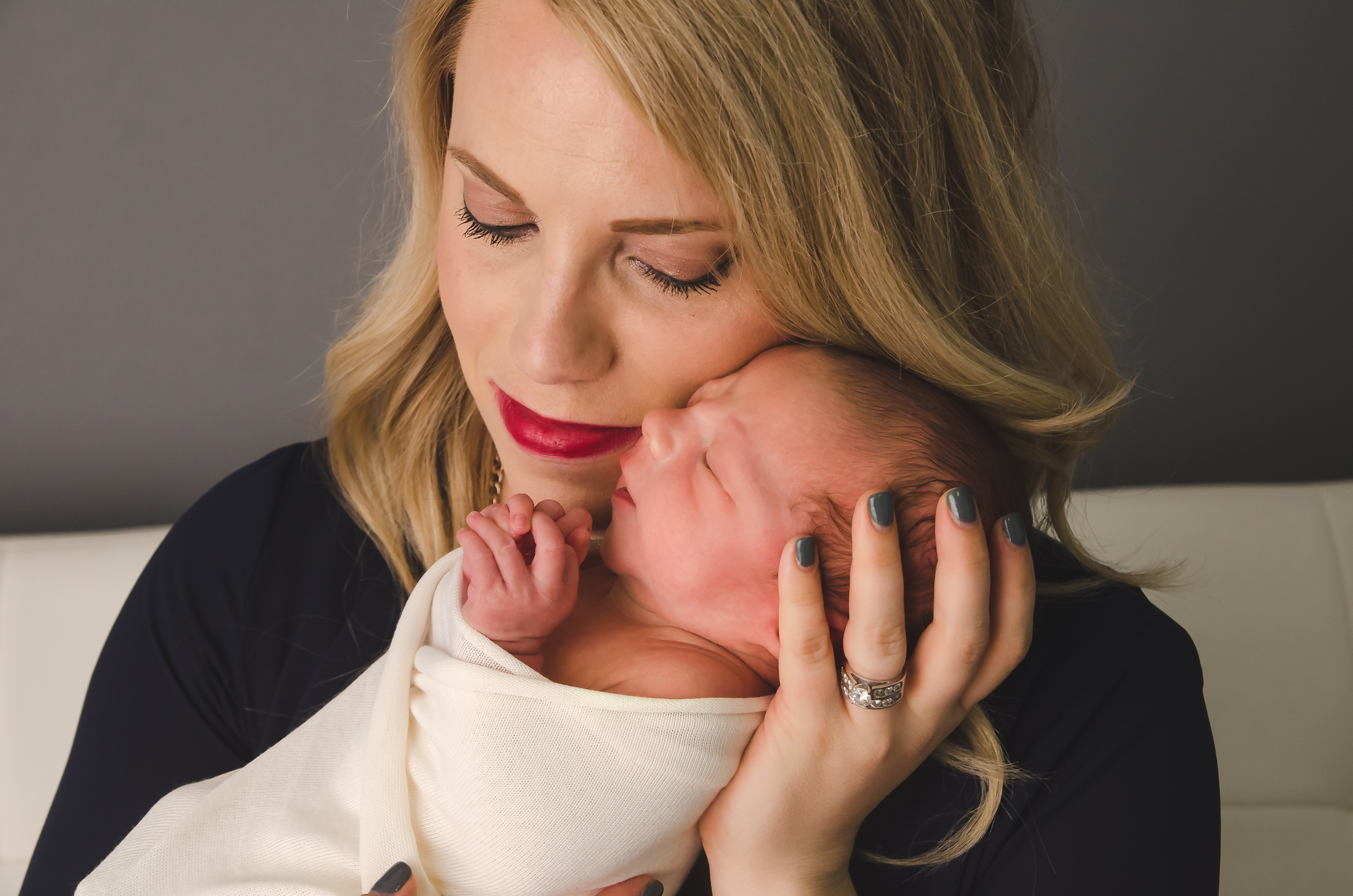 Indianapolis moms cuddles her swaddled newborn boy