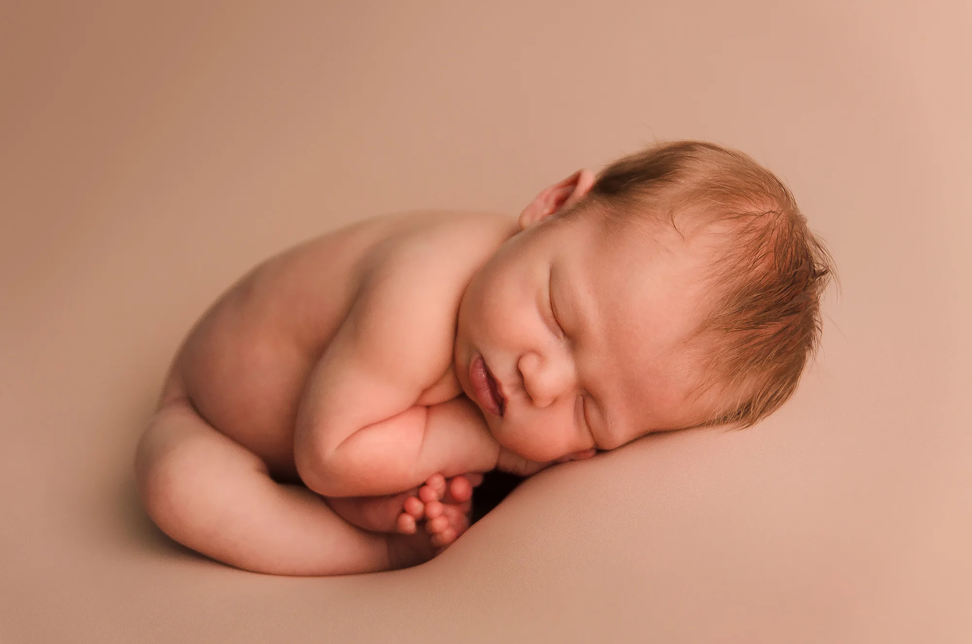 photo of a newborn baby in a pose at a photography session