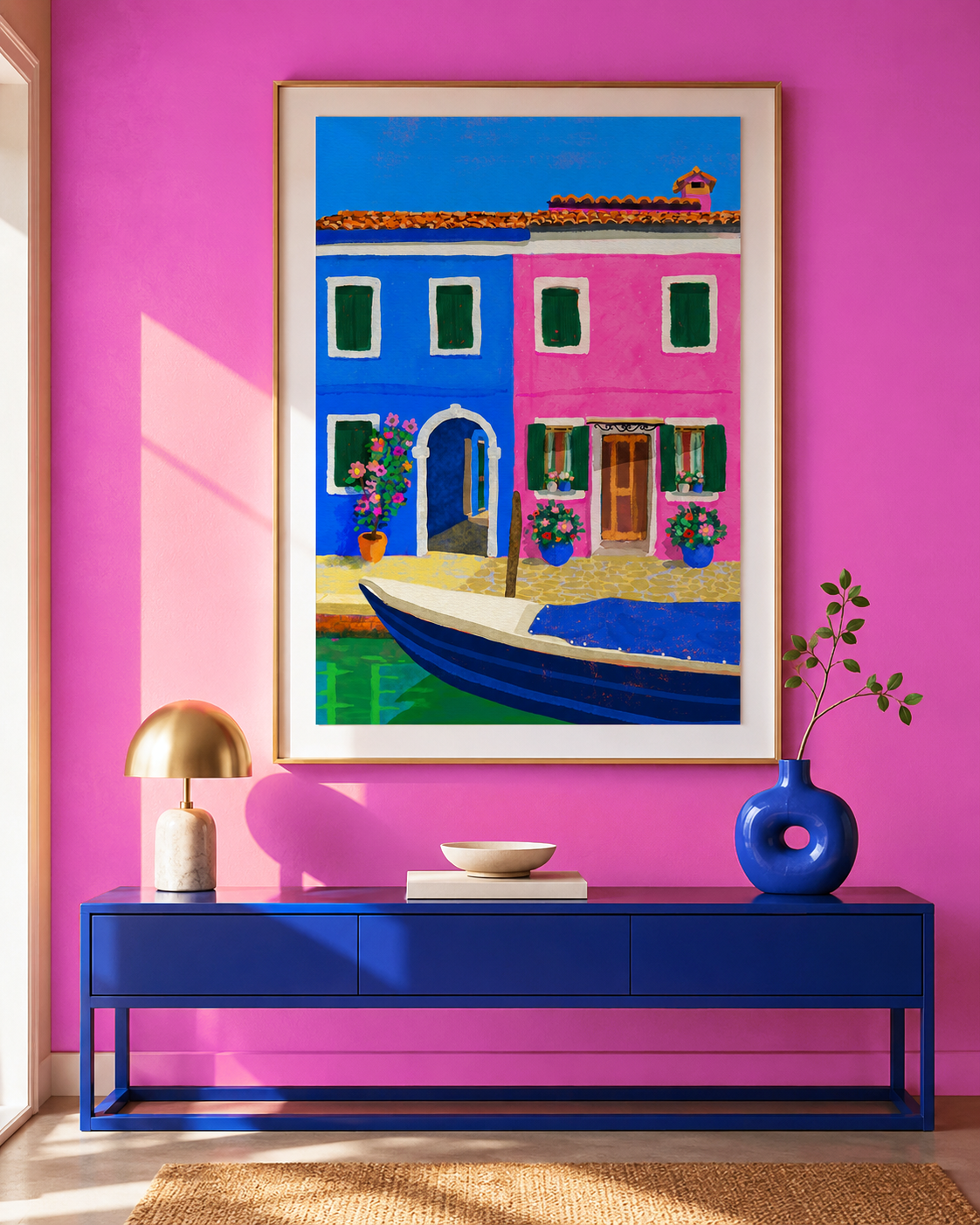 Tirage d'art coloré Burano de Claire Maoui, cadre doré sur un mur rose vif au-dessus d'une console bleu cobalt