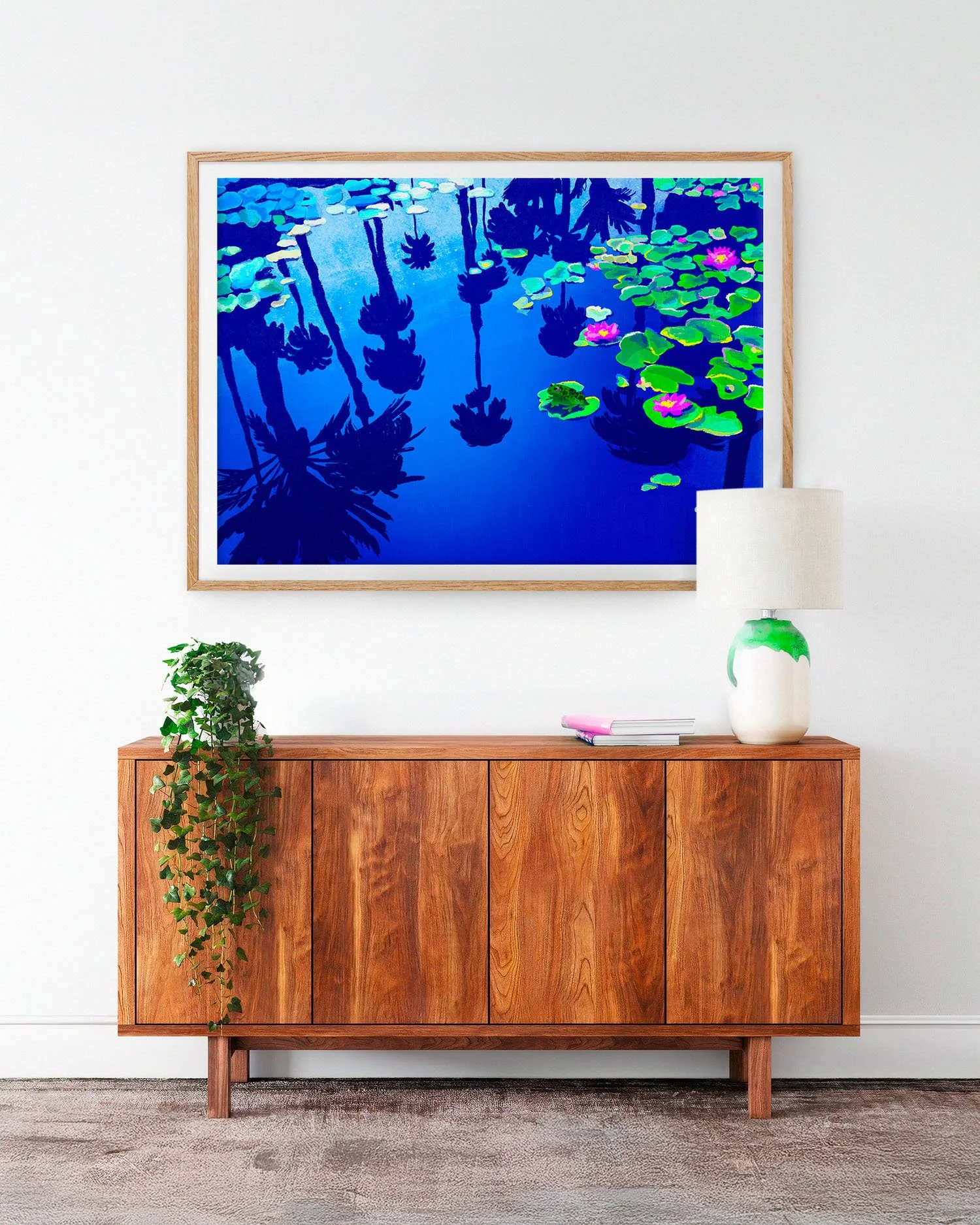 Palms in Blue de Claire Maoui au-dessus d'un buffet mid-century avec lampe blanche et plantes