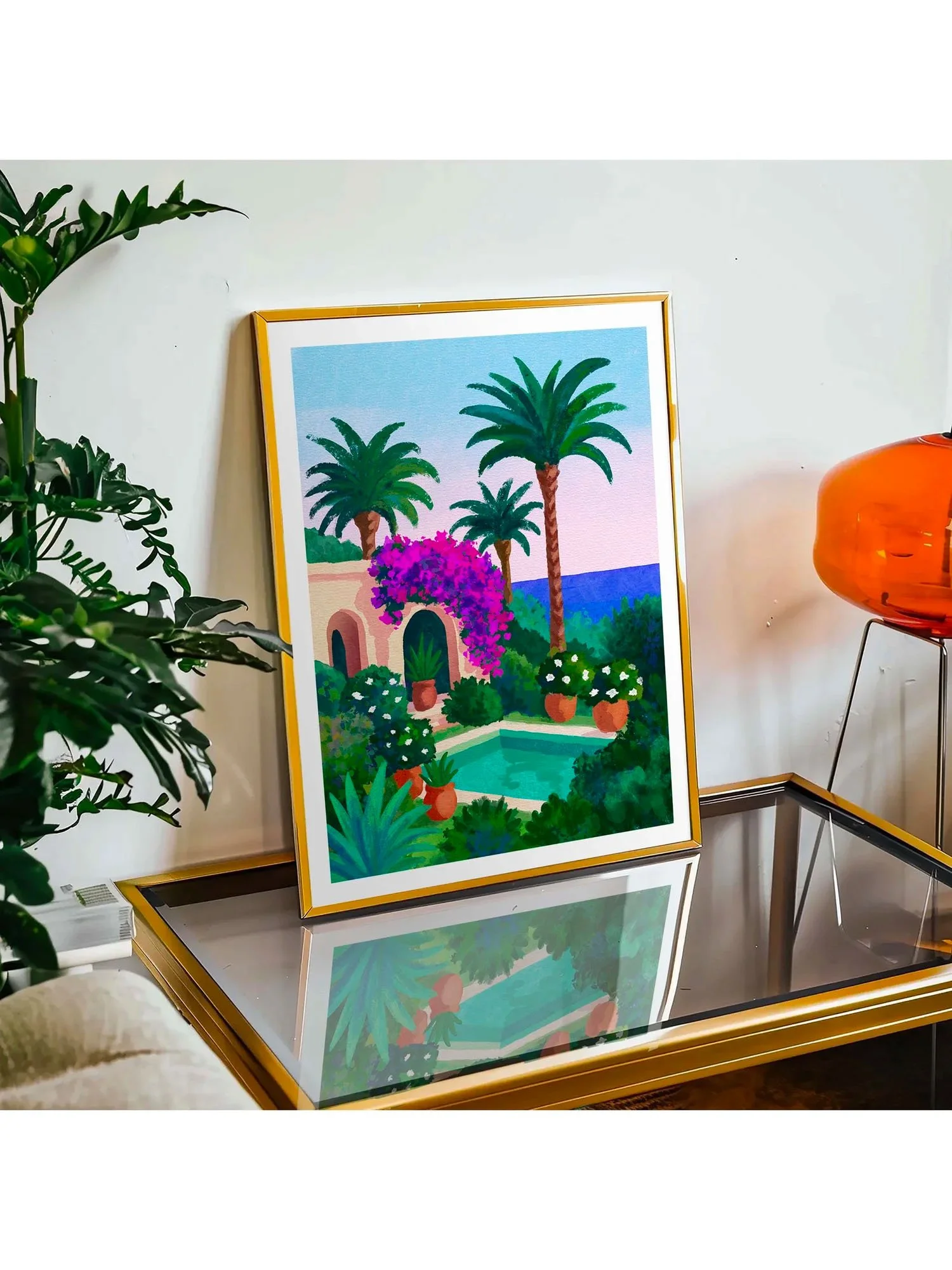 Tirage Attention : Tanger ! encadré en doré sur table basse design avec lampe orange
