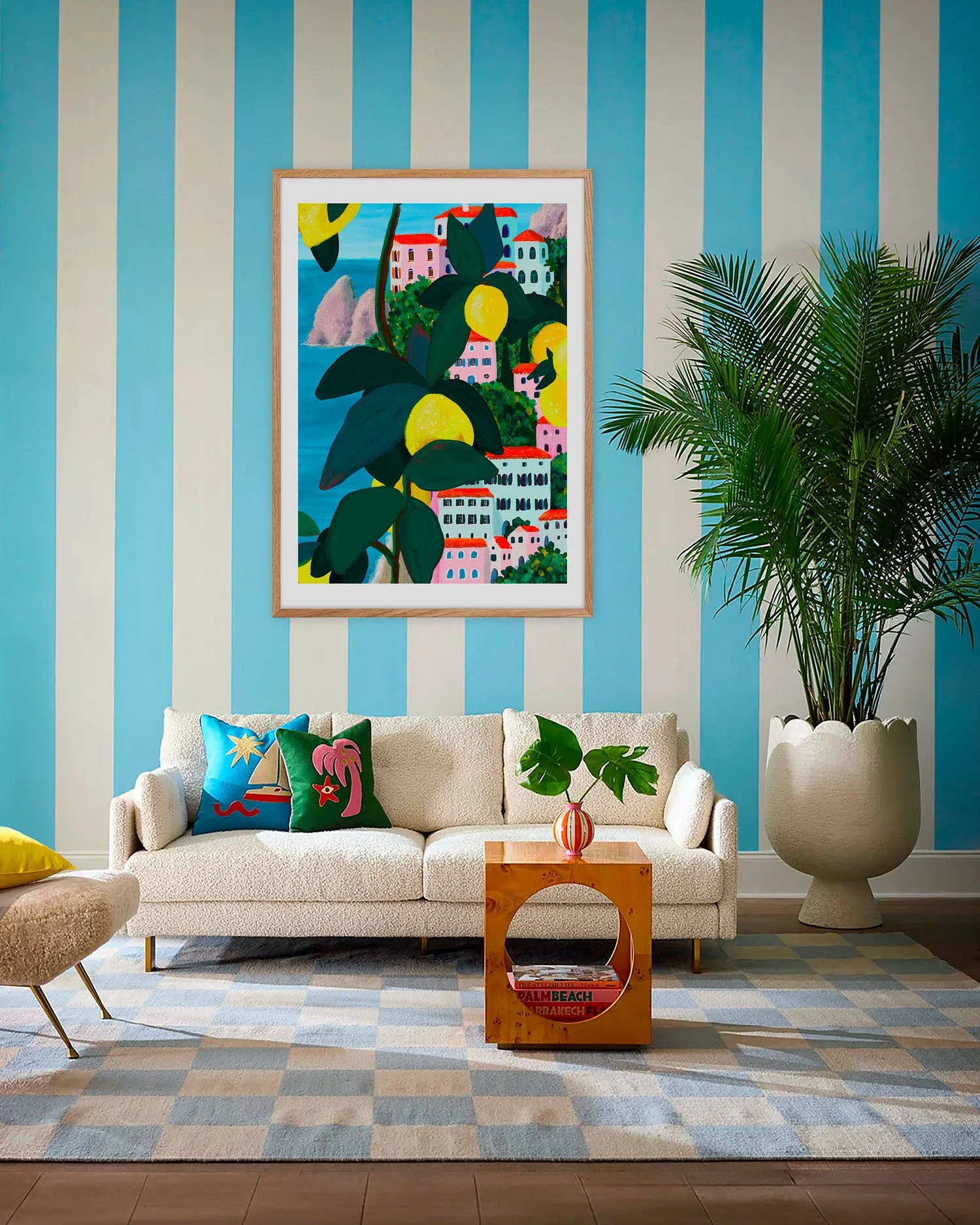 Tirage côte amalfitaine sur mur rayé bleu dans un salon bohème avec canapé bouclette et palmier
