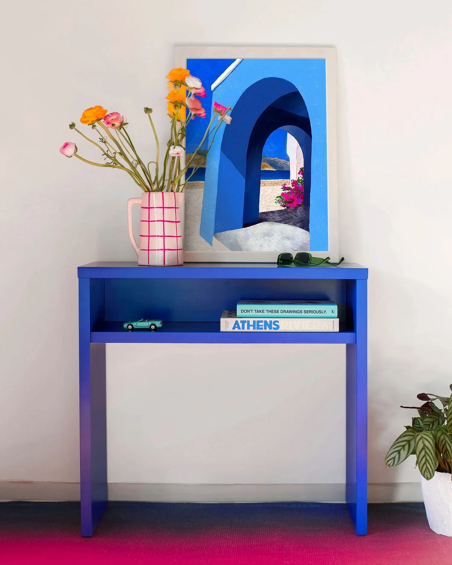 Portes Ouvertes de Claire Maoui sur console bleu Klein avec bouquet coloré et déco contemporaine