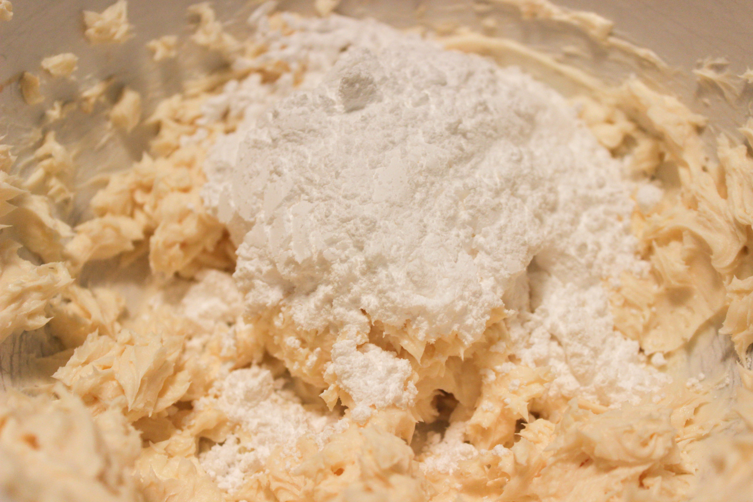 Scrape the sides of the bowl, and add the confectioners' sugar in parts, about half a cup at a time. Beat slowly at first so the sugar doesn't fly into the air and out of your frosting! Gradually increase the speed as the mixture is combined and repeat with each addition of sugar until...