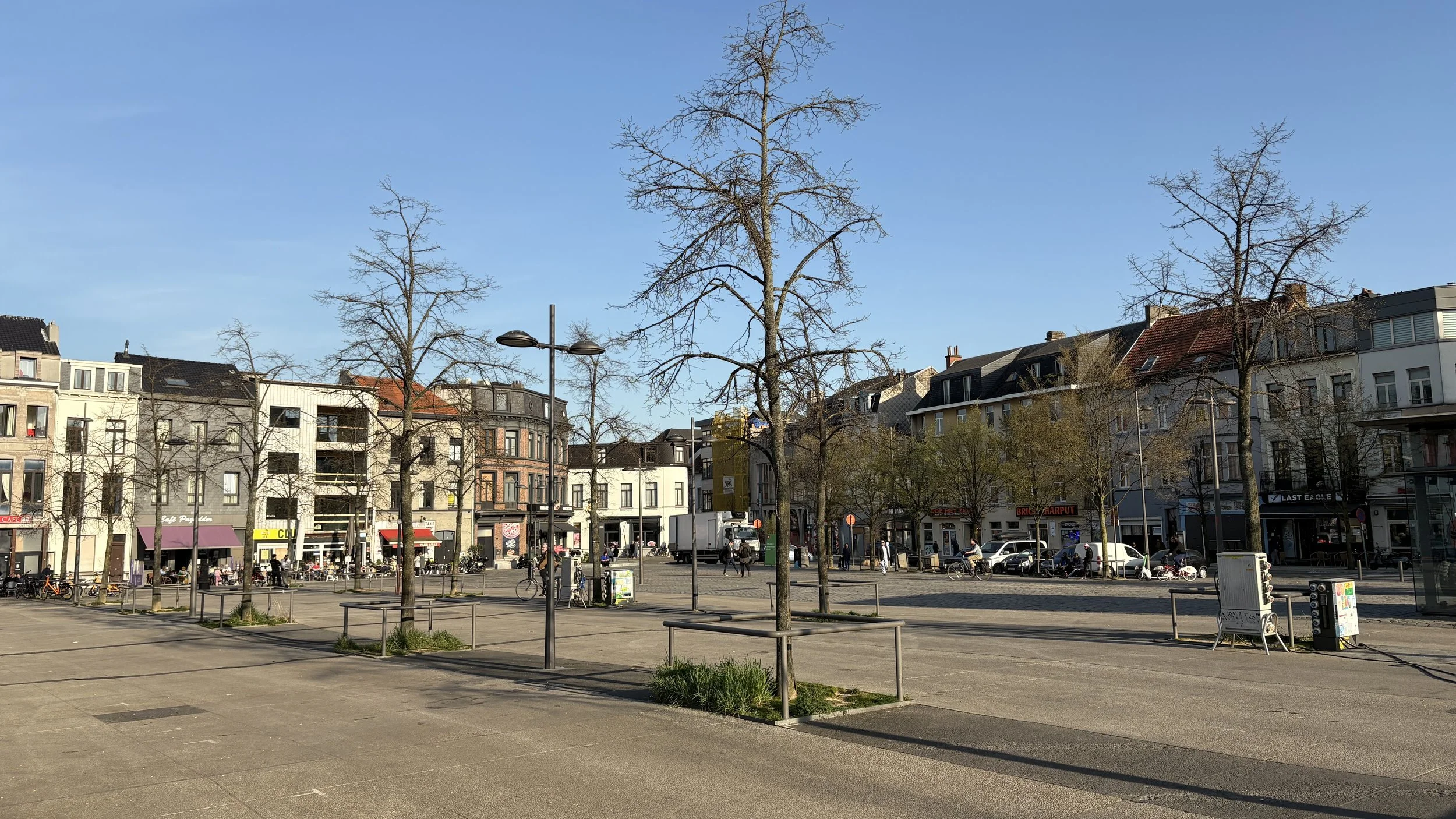Vandaag overheersen verharding en beperkte groeikansen voor bomen, waardoor het plein weinig verblijfskwaliteit biedt.