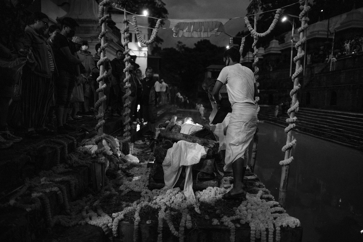 Antyeṣṭi, "last sacrifice" Pashupatinat, on the banks of the Bagmati River, a prister lays extra firewood.