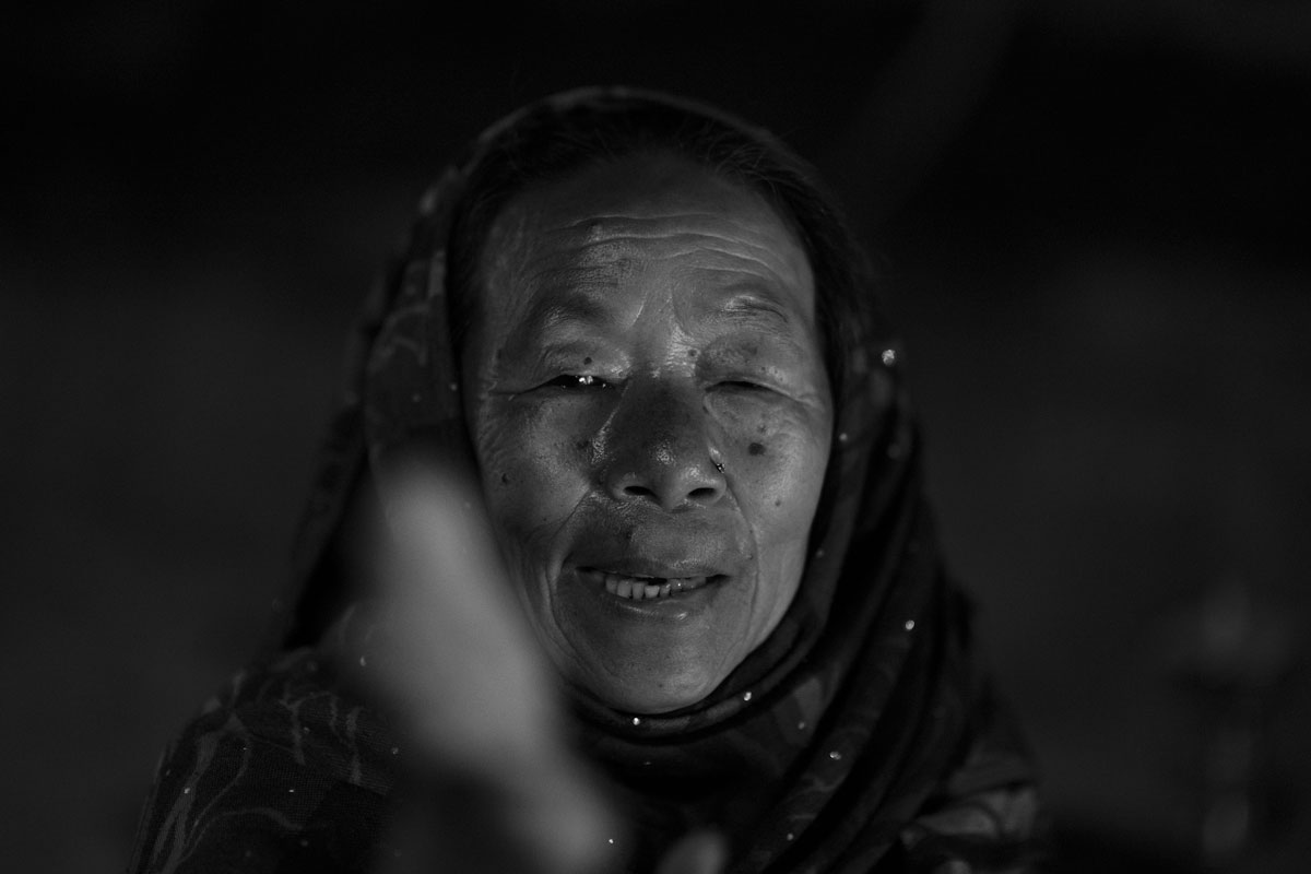A woman is posing on a alley of the Boudhanath Stupa.