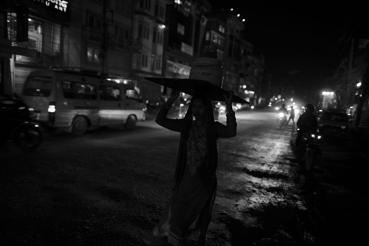 A Laborer on Boudhanath Street after a heavy monsoon rain.
