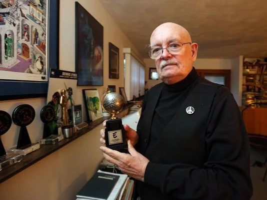 Denny O'Neil holding an Eisner Award.
