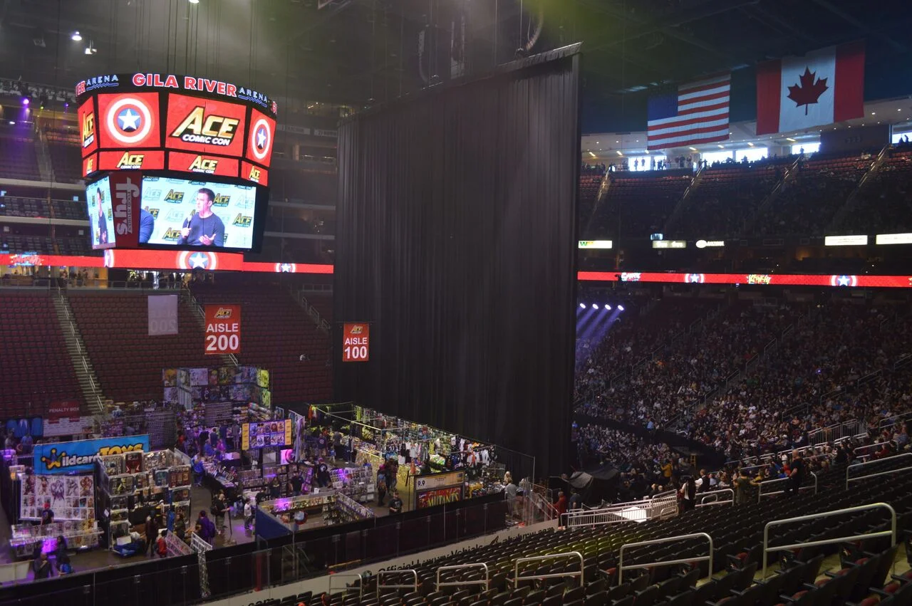 The main stage (with a packed-in audience) behind the show floor.