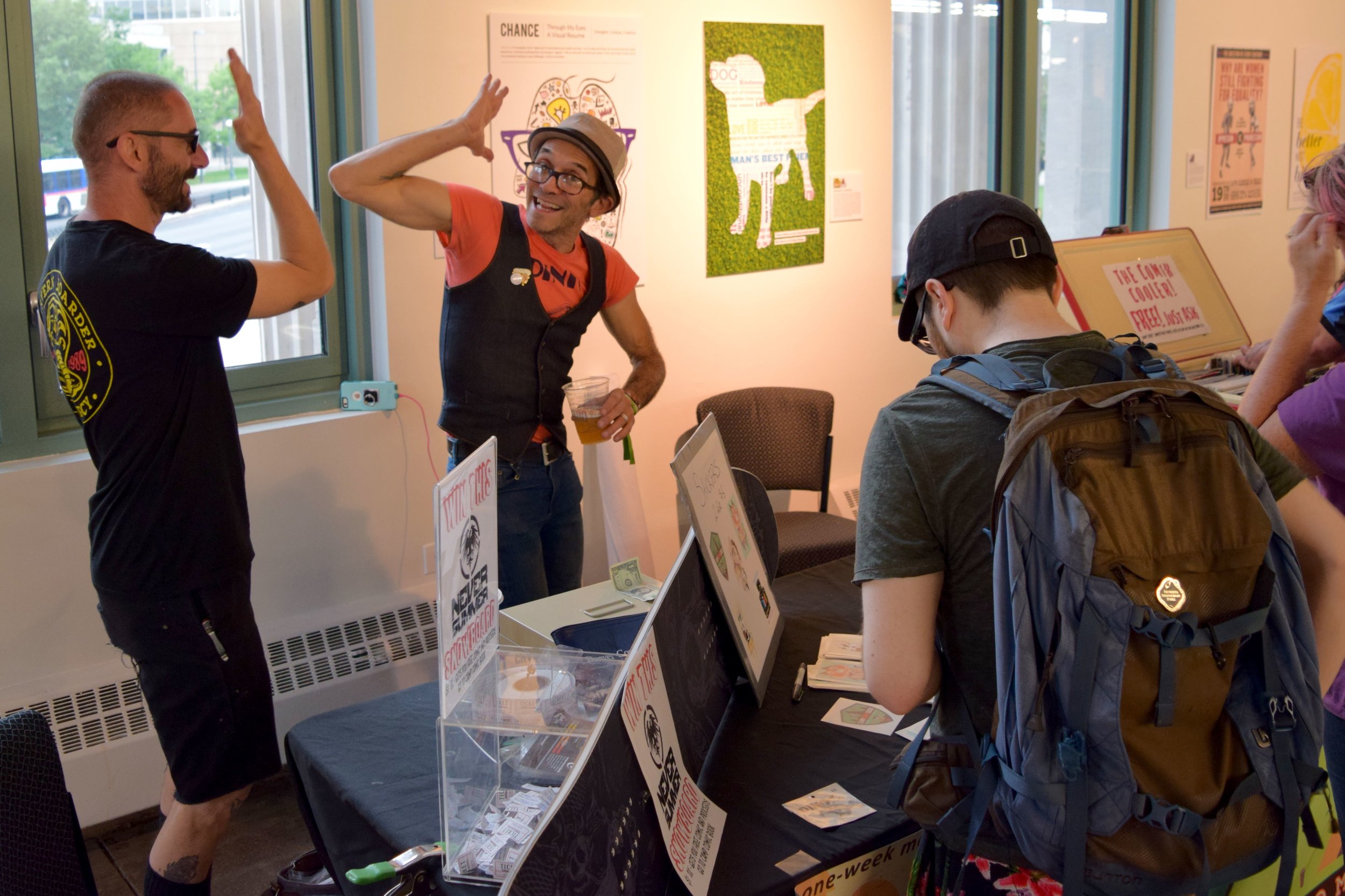 Charlie La Greca strikes a pose behind the DINK! table at Denver Zine Fest 2018 .