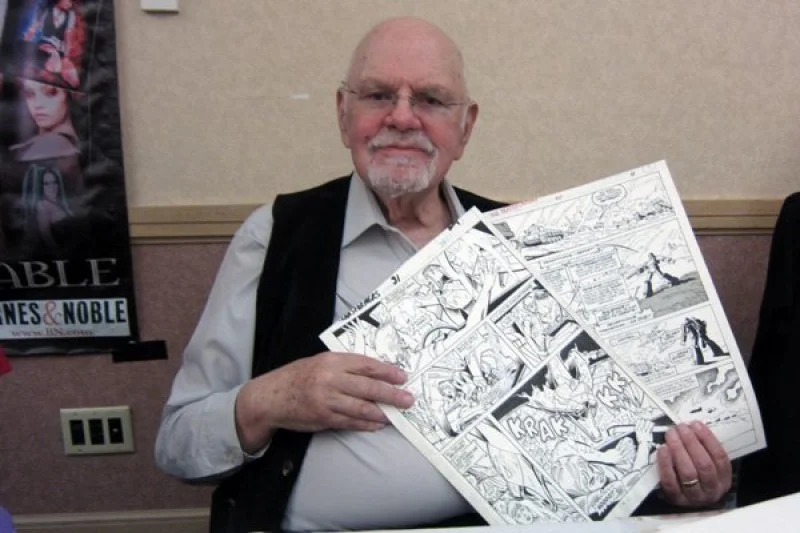Don Perlin holding up some of his original comic pages.