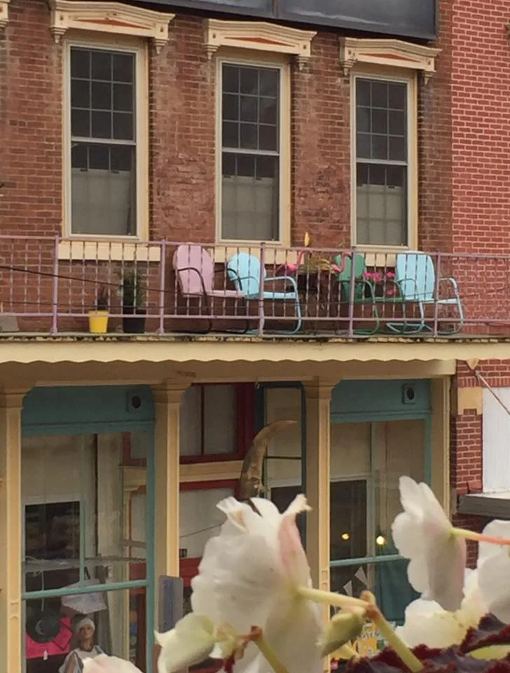 Two story brick buildings lined the streets of McGregor, Iowa. A typical river town with stores on the first level and apartments on the second, complete with balconies with chairs for relaxing and reading and looking over the town.