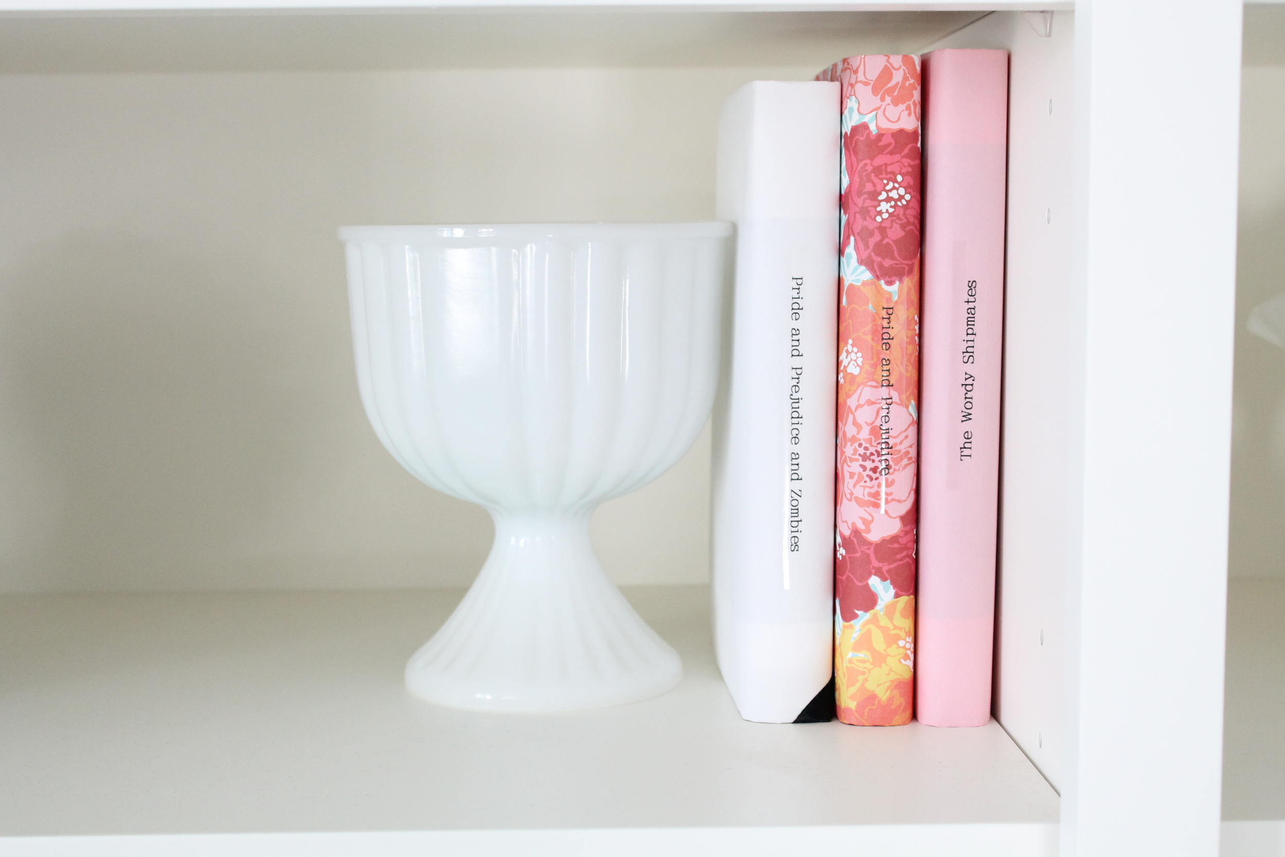 Built in bookshelf decorating ideas. Style a bookshelf with a cohesive color pallet by covering books with pretty paper. Add some glass objects and small frames to round out the design.