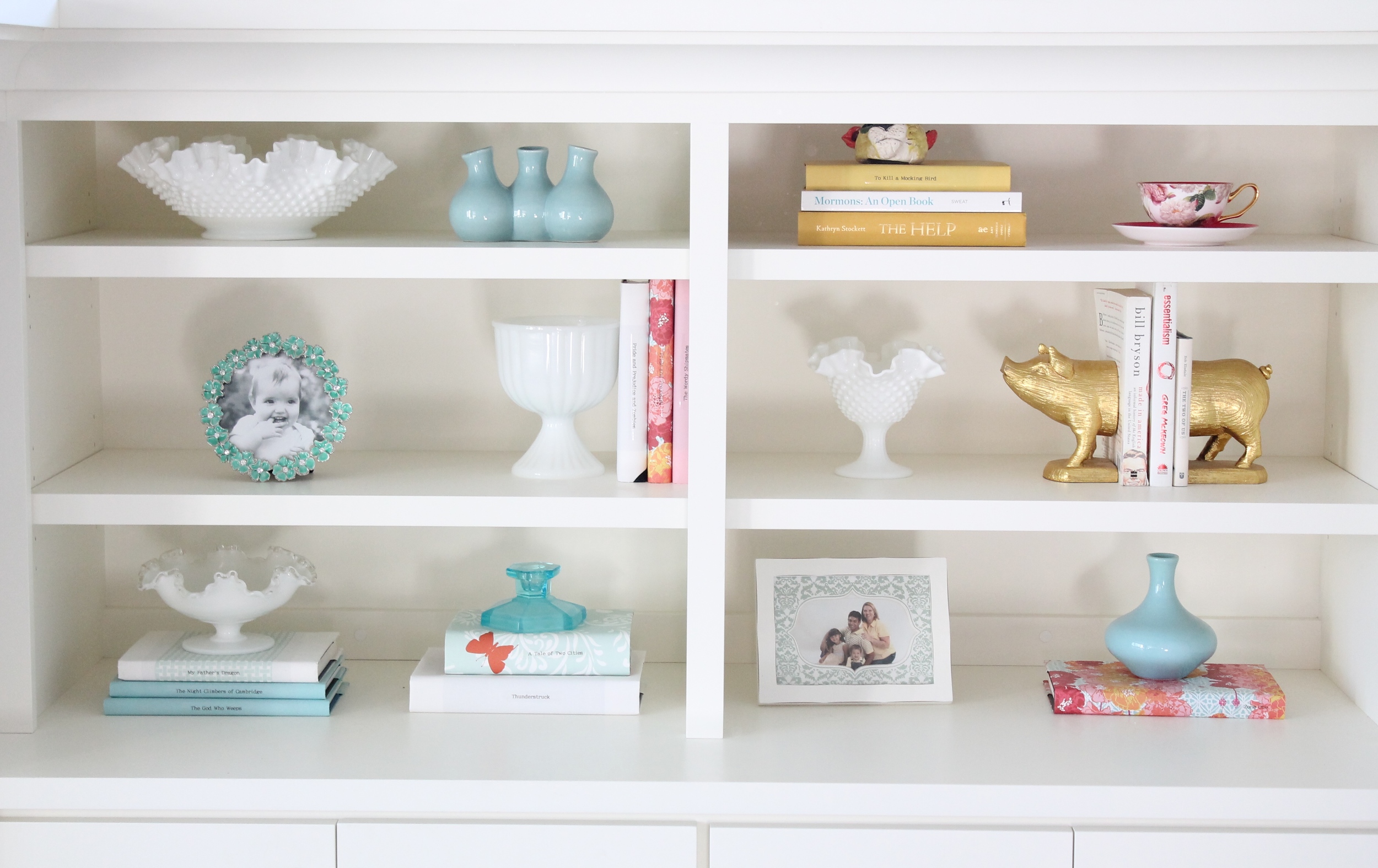 Built in bookshelf decorating ideas. Style a bookshelf with a cohesive color pallet by covering books with pretty paper. Add some glass objects and small frames to round out the design.