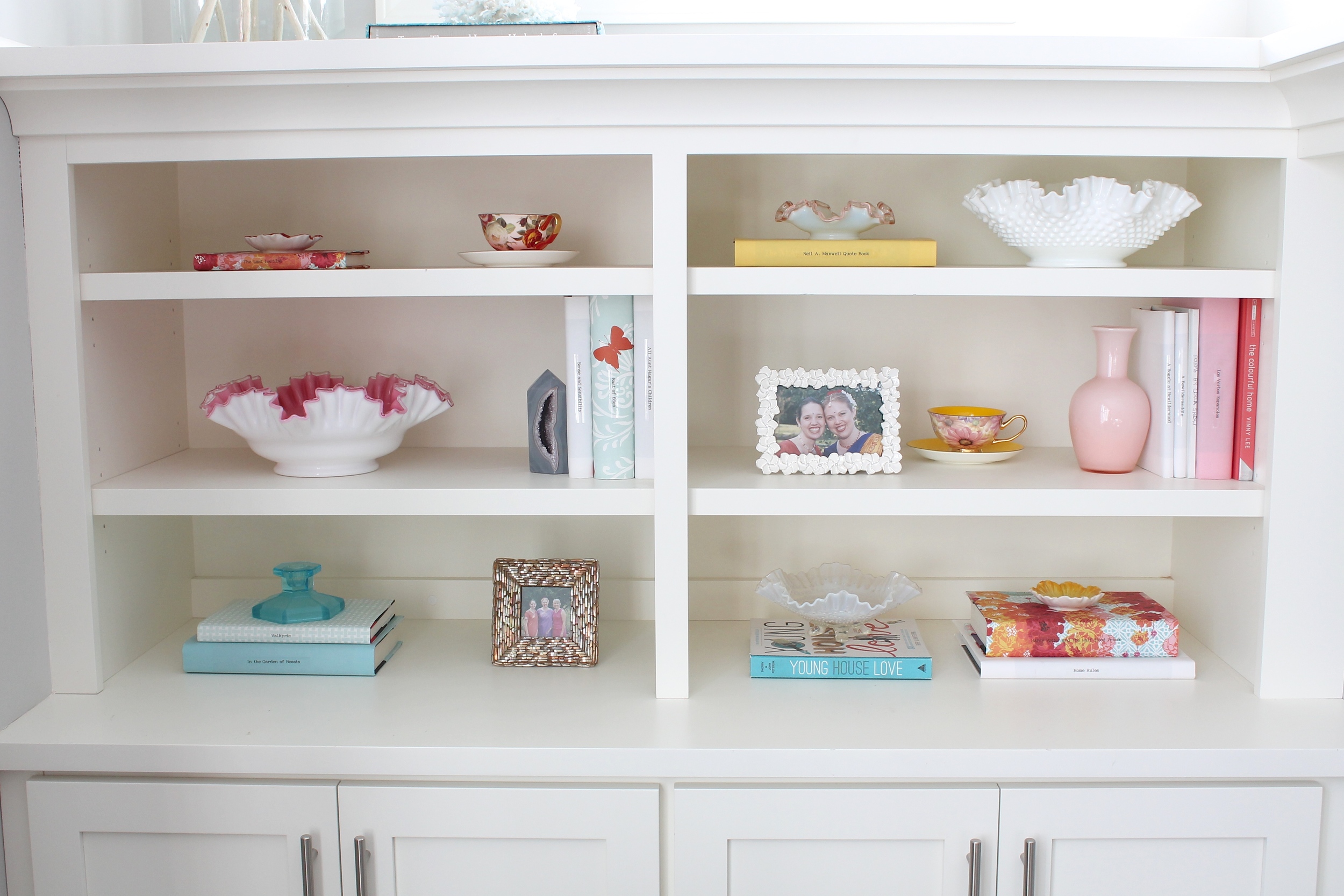 Built in bookshelf decorating ideas. Style a bookshelf with a cohesive color pallet by covering books with pretty paper. Add some glass objects and small frames to round out the design.