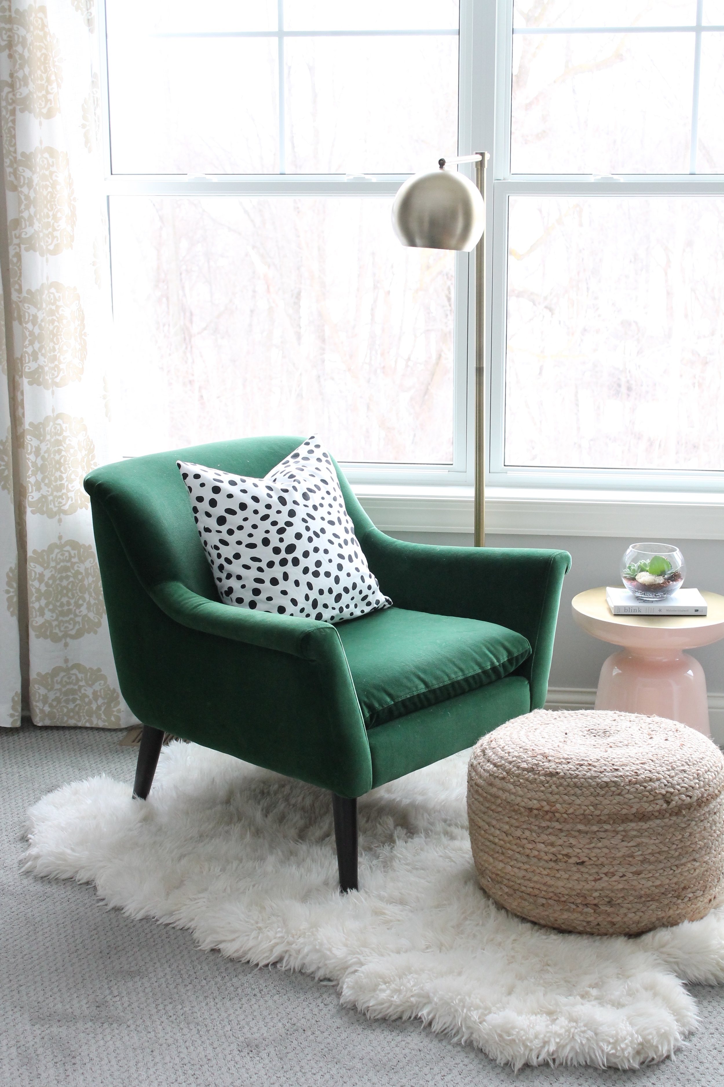 Lovely little reading nook for the master bedroom. Green velvet chair, dalmatian pillow, pink and gold martini table, and a jute poof all on a sheepskin rug.