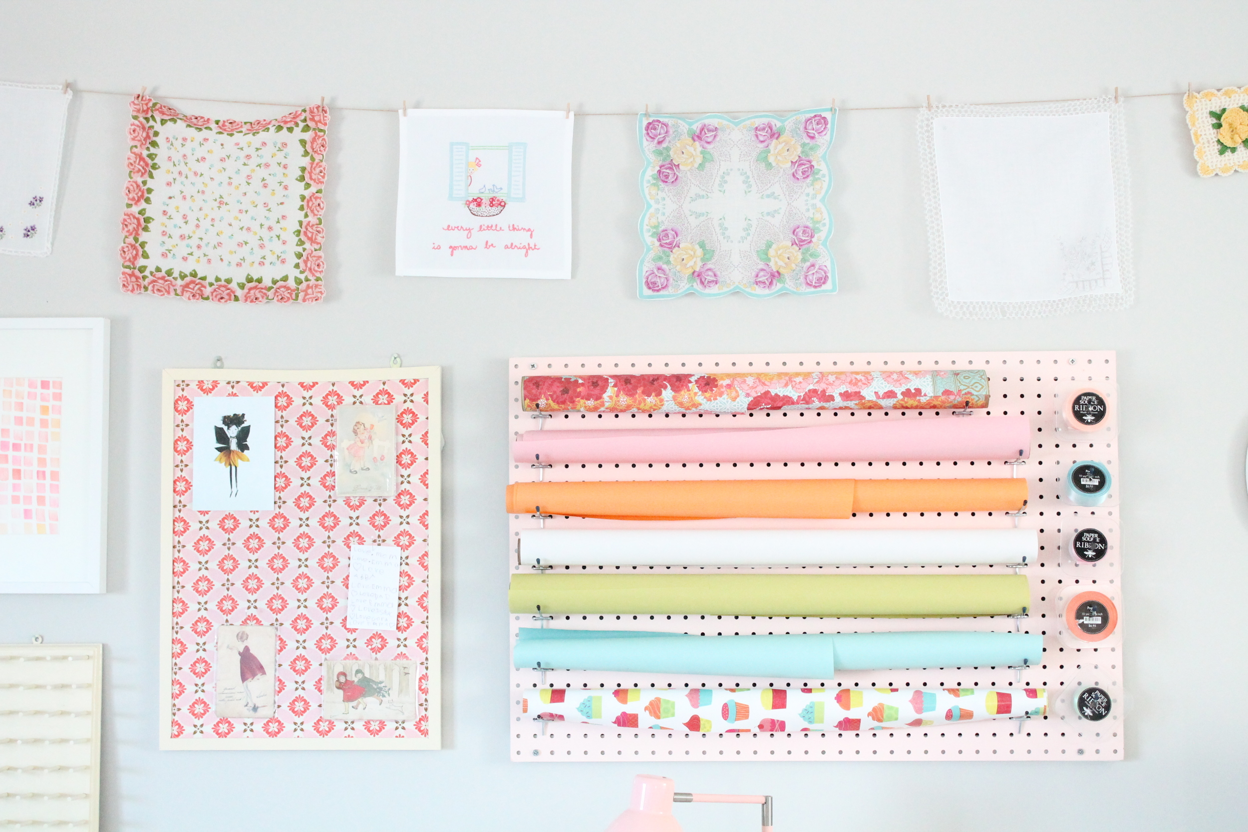 Tessie Fay's family craft room. Pegboard wrapping station, fabric covered bulletin boards and vintage handkerchiefs. So pretty!