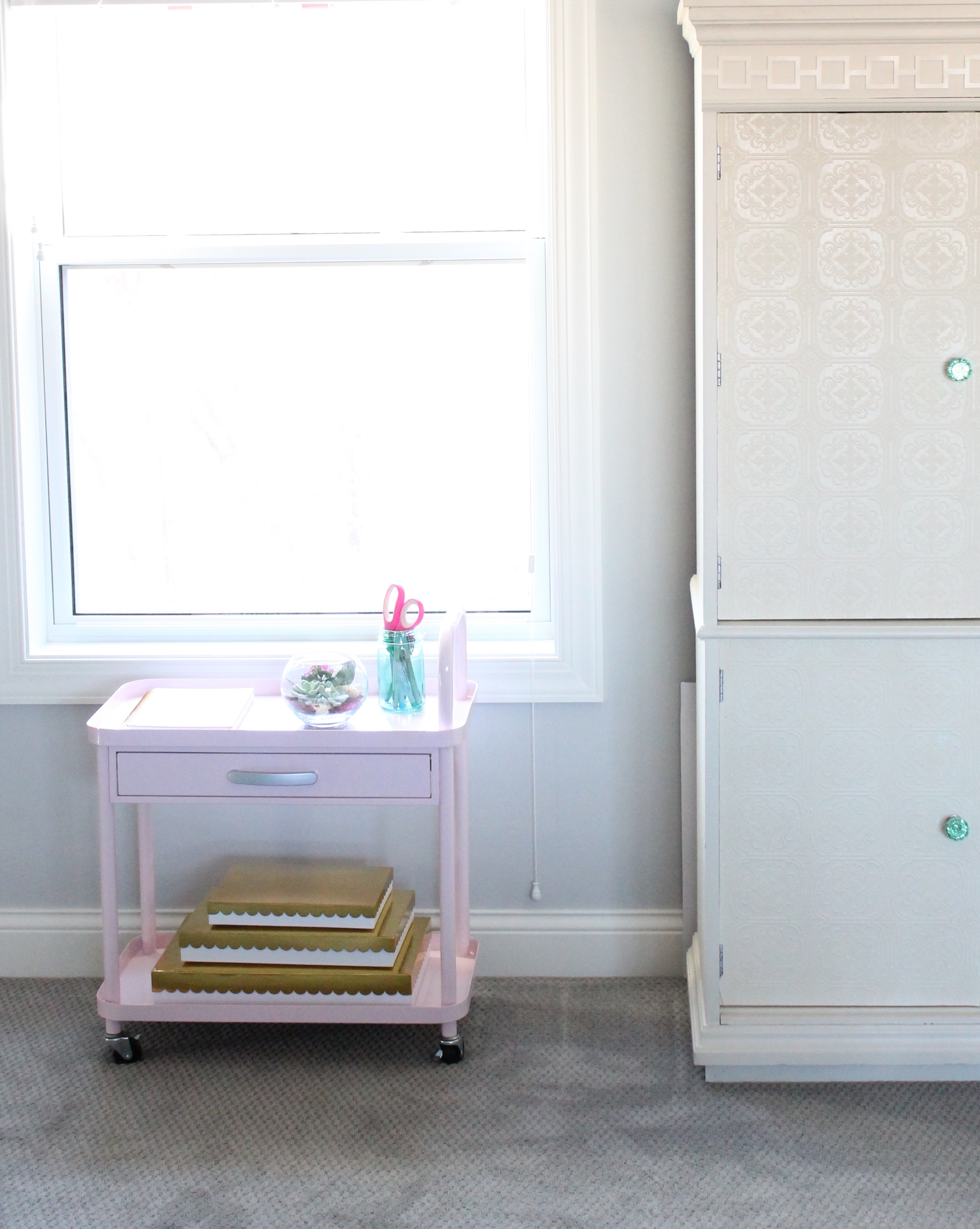 Adorable pink rolling cart in this family craft room.