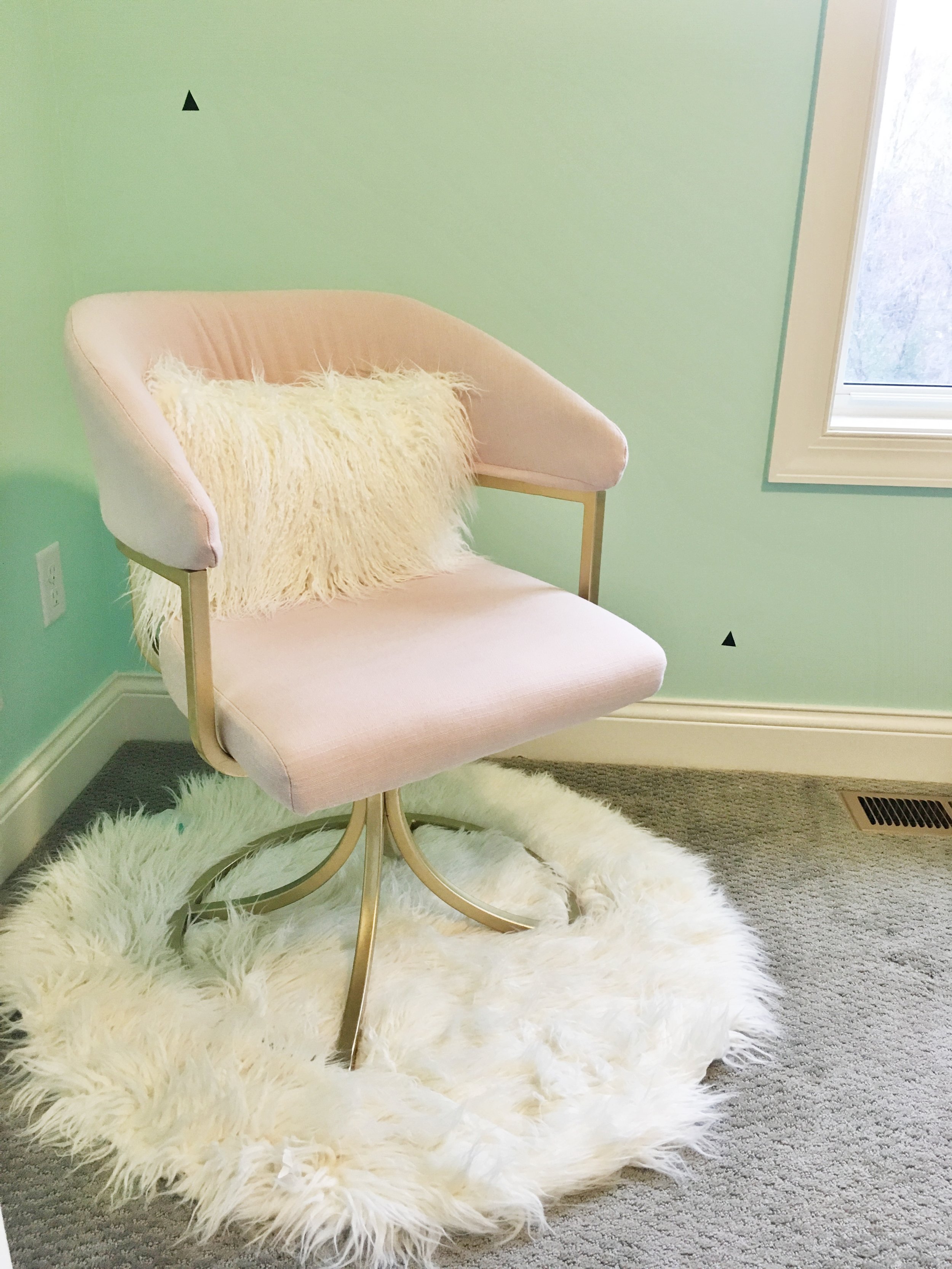 Pink Chair from Home Goods with mint walls and cozy rug