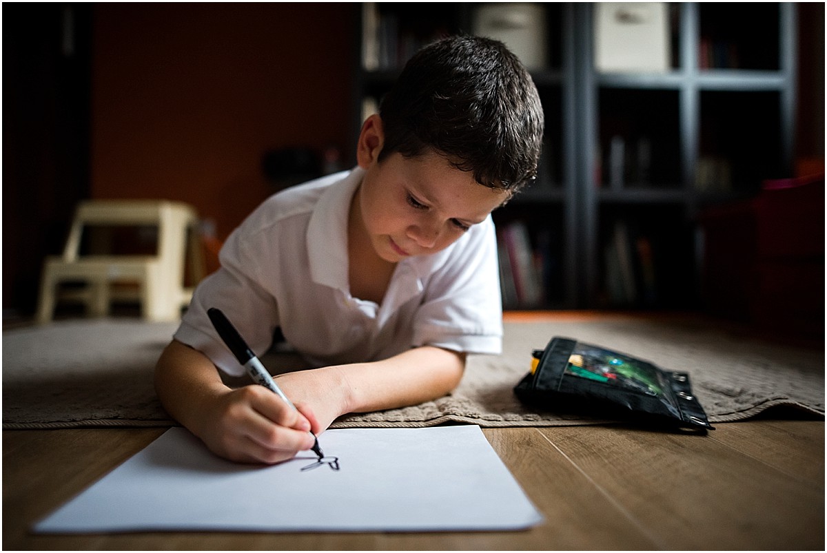 boy drawing pictures on the floor during in-home lifestyle photography session in Costa Rica