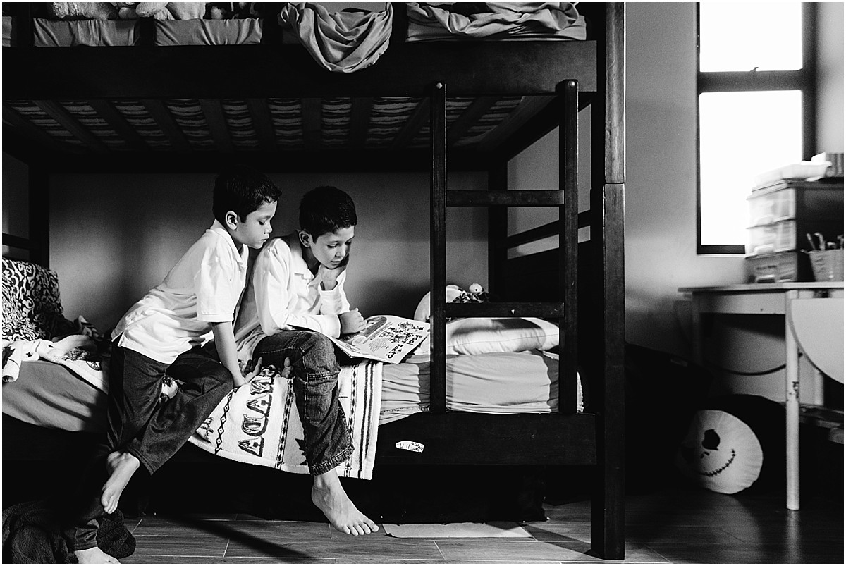 brothers reading on their bed during family documentary photo shoot in Santa Ana, Costa Rica