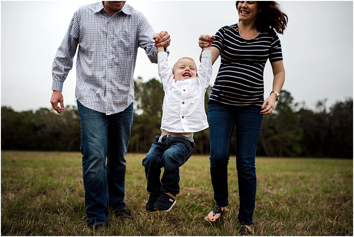 Family playing in a field during family photoshoot | Oviedo Lifestyle Family Photographer